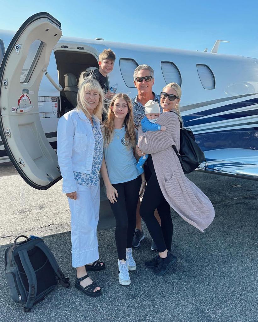Heather Rae Young poses by plane with parents, stepkids and son Tristan