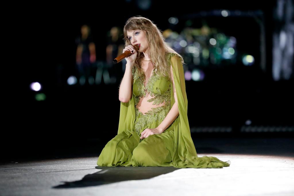 Taylor Swift performing onstage in a green gown.