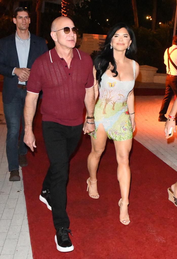Jeff Bezos and Lauren Sánchez walking together and holding hands.
