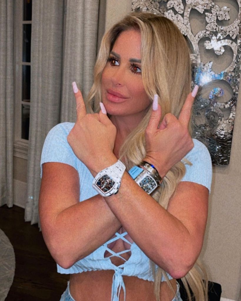 Kim Zolciak throwing up her middle fingers.