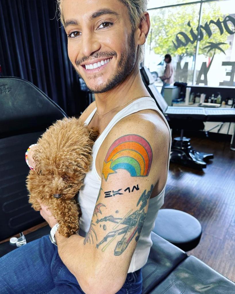 Frankie Grande holding a dog and smiling.