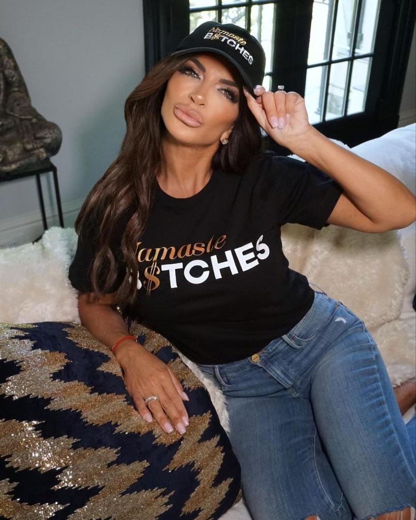 teresa giudice sitting on a couch and tipping her hat