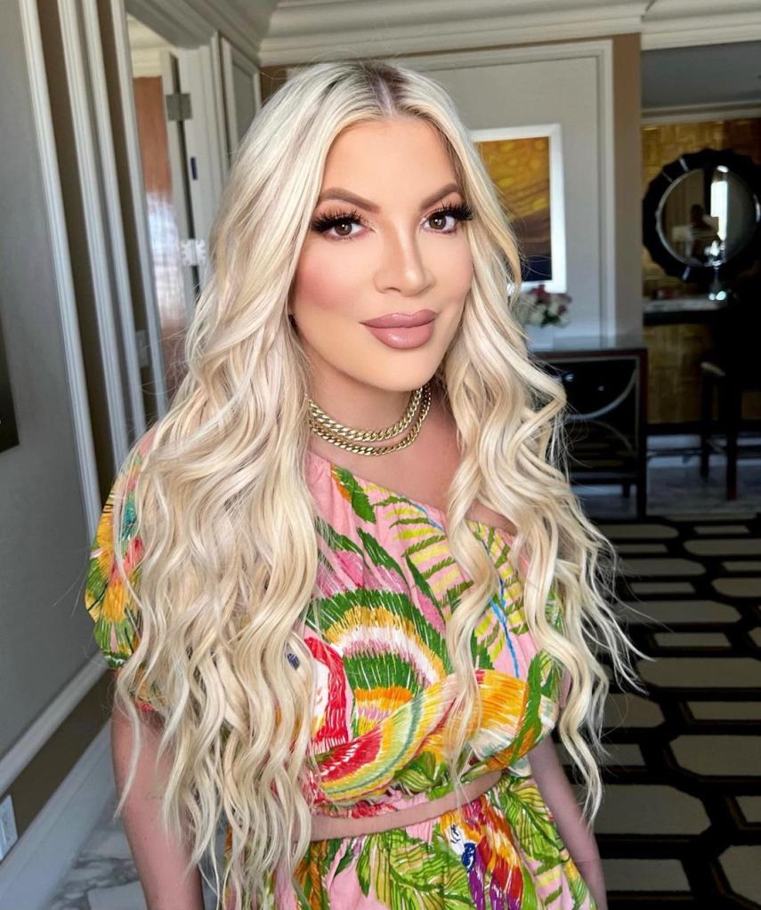 Tori Spelling poses in colorful top