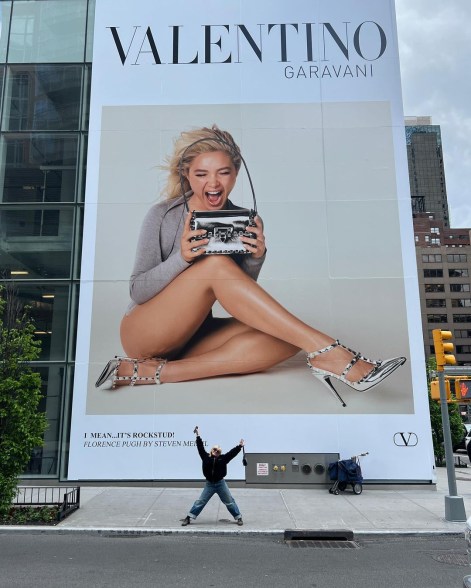 Florence Pugh standing in front of a billboard of herself