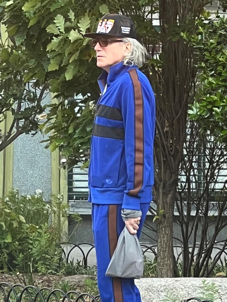 Daniel Day Lewis walks in blue sweatsuit