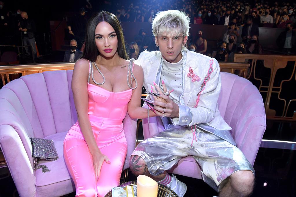 Machine Gun Kelly and Megan Fox sitting on a couch together.