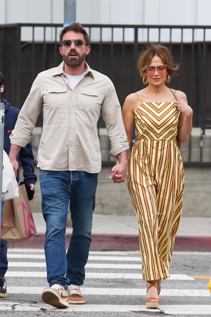 Jennifer Lopez and Ben Affleck holding hands.