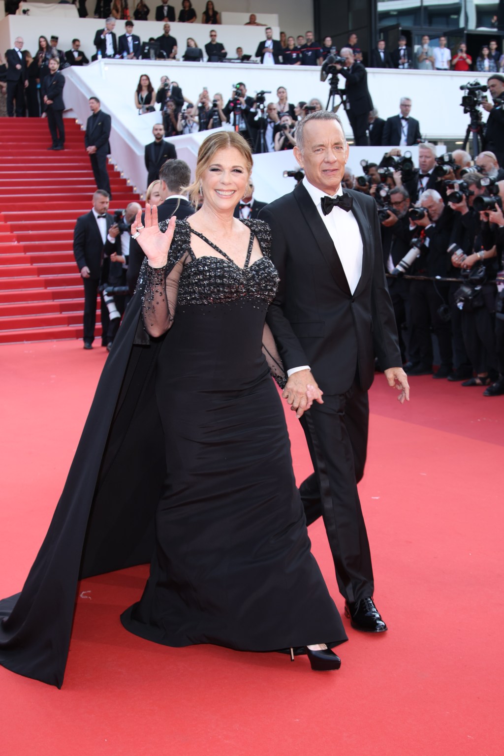 rita wilson and tom hanks walking on a red carpet