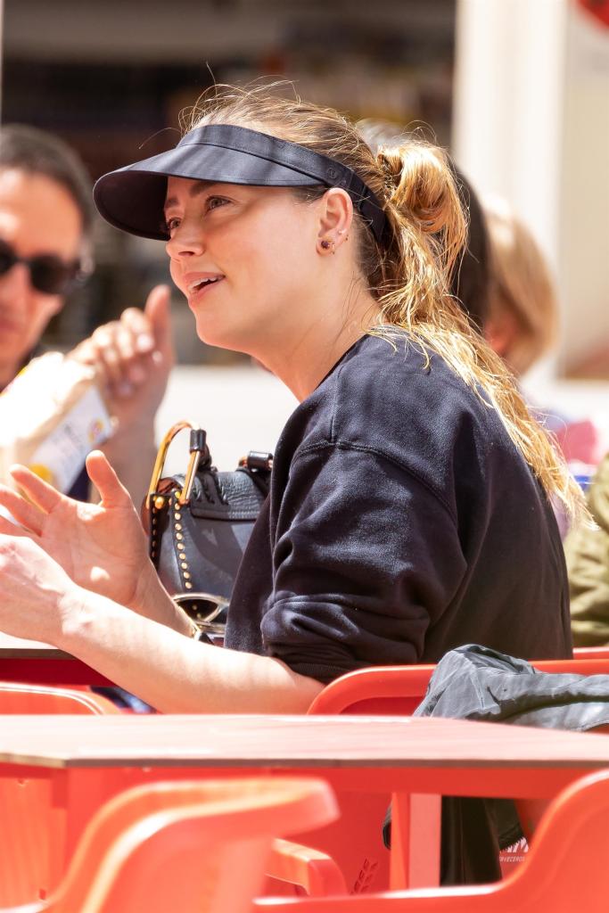 amber heard sitting at a table outside