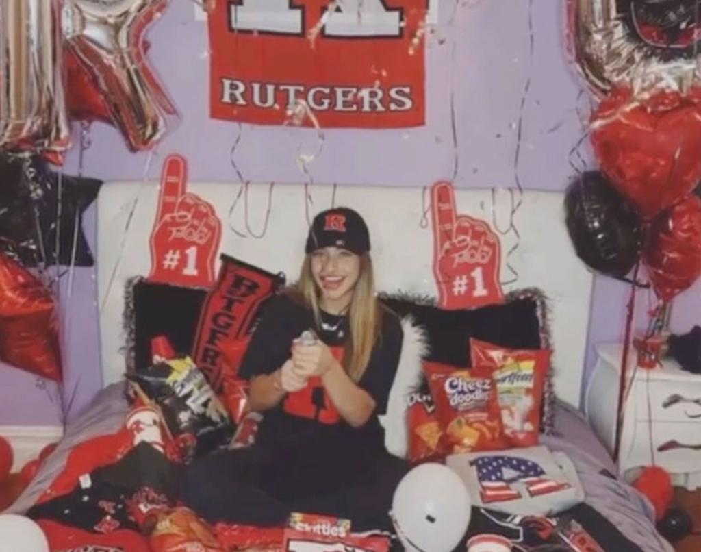 Gia Giudice sitting on a bed with Rutgers University merch