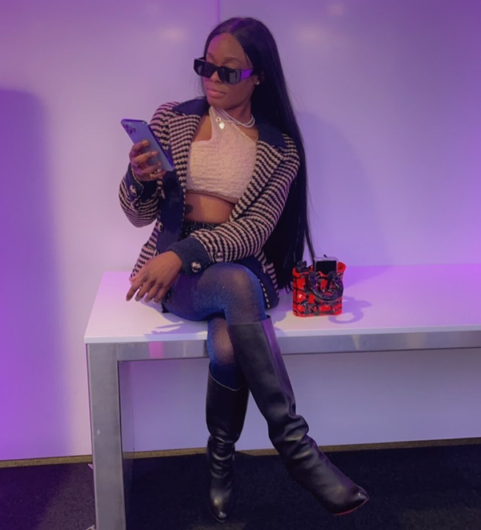 Azealia Banks sitting on her phone.