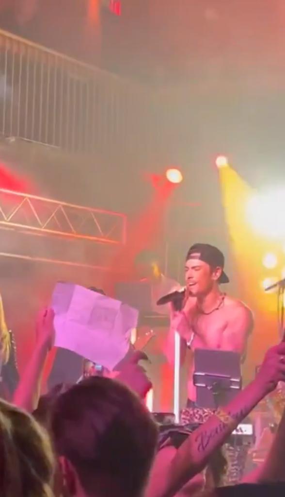 Tom Sandoval sings as fan holds up "Team Ariana" sign