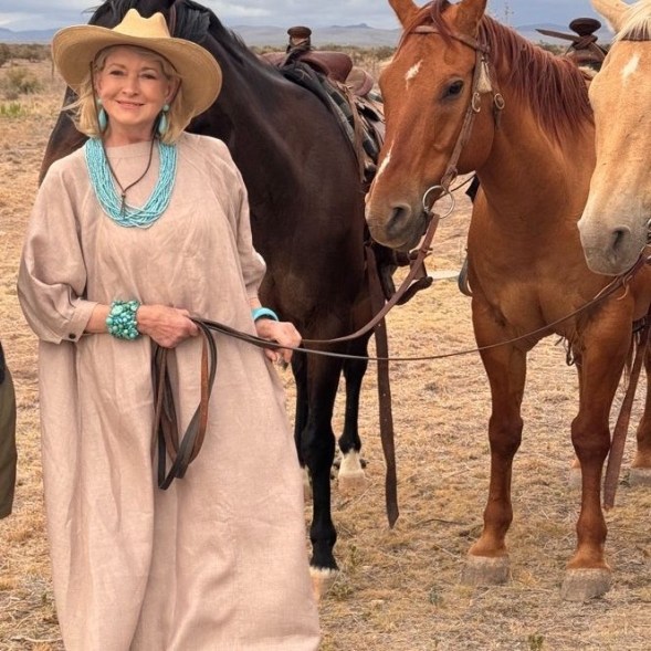 Martha Stewart leads horses on a ranch in Texas.