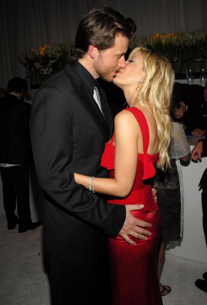 Dean McDermott and Tori Spelling kissing.