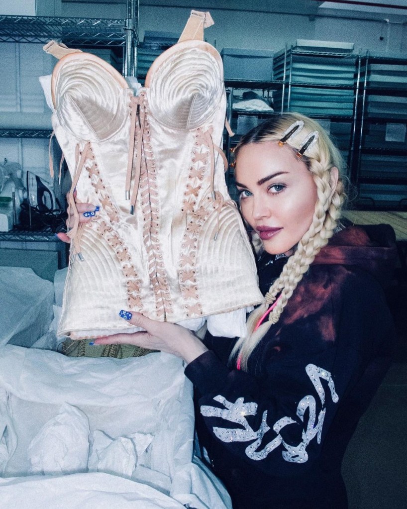 Madonna holding up a corset costume from her archives