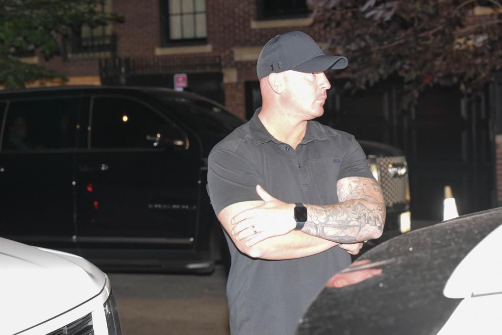 A security guard in front of a car.