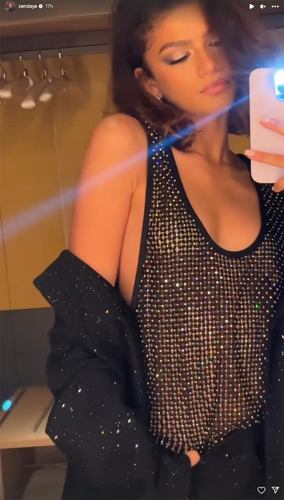 Zendaya in black tank top, blazer hanging off shoulder in mirror selfie