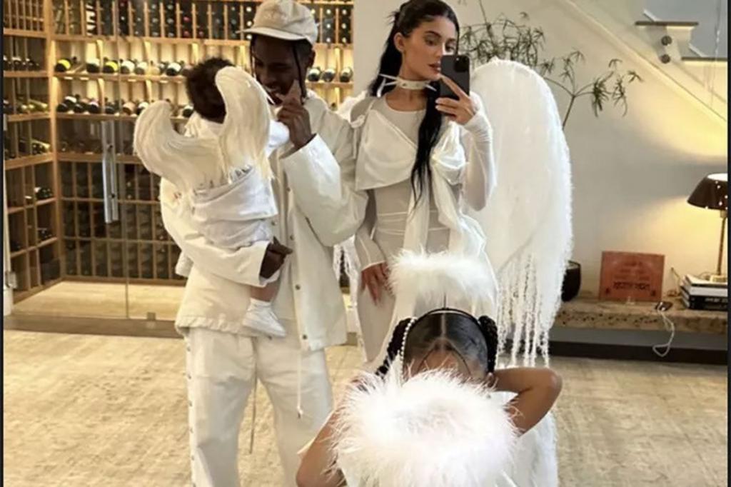 Travis Scott, Kylie Jenner, Stormi Webster and Aire Webster posing together in angel costumes.