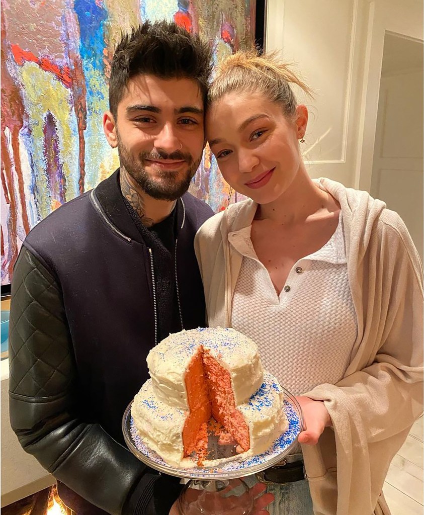 Zayn Malik and Gigi Hadid holding a cake. 
