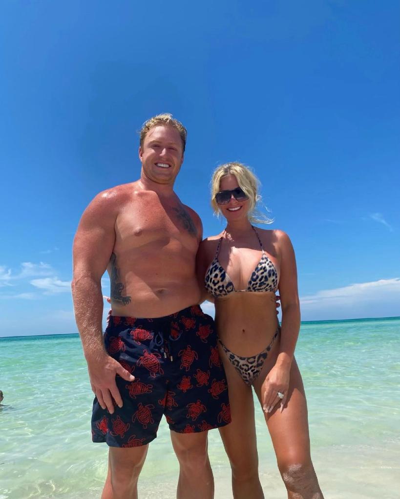 kroy biermann and kim zolciak posing on the beach in their swimsuits