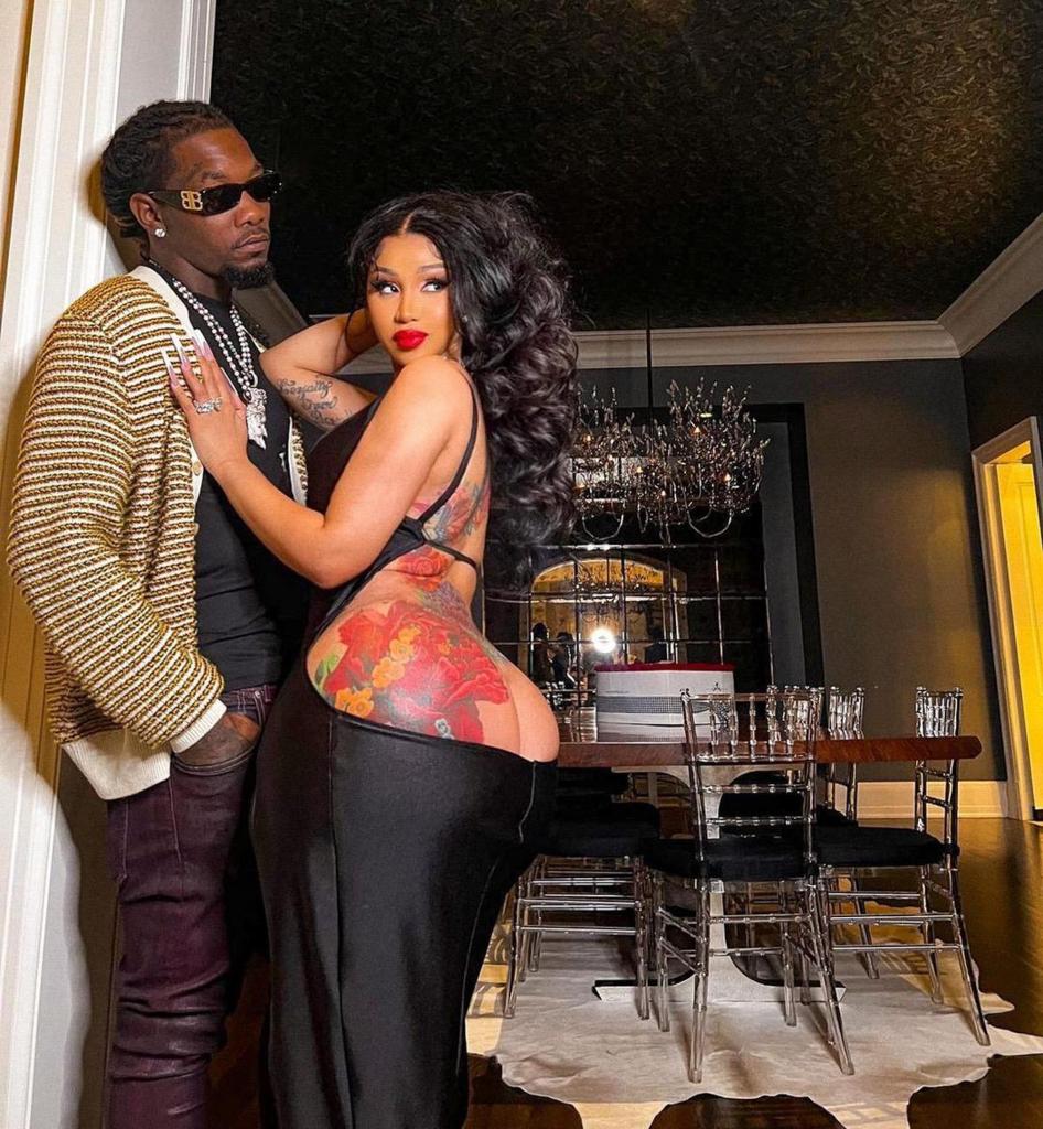 Cardi B and Offset leaning against a wall.