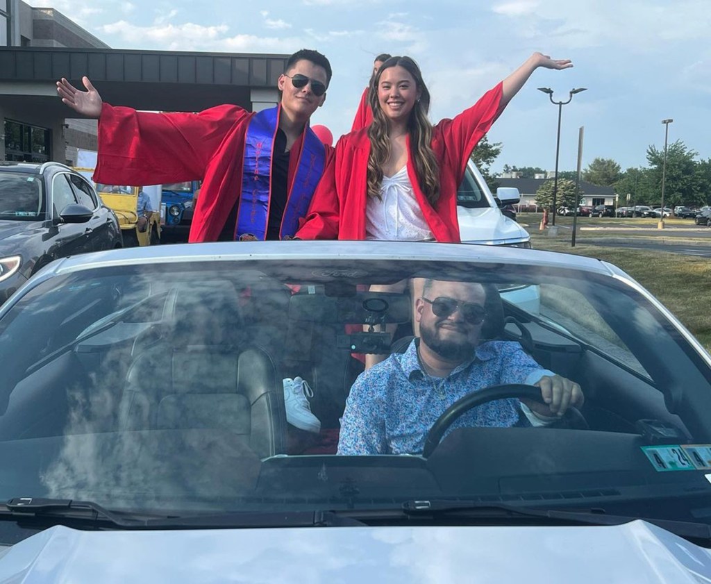 Hannah Gosselin and Collin Gosselin in the back of a convertible while Jon Gosselin is in the driver's seat.