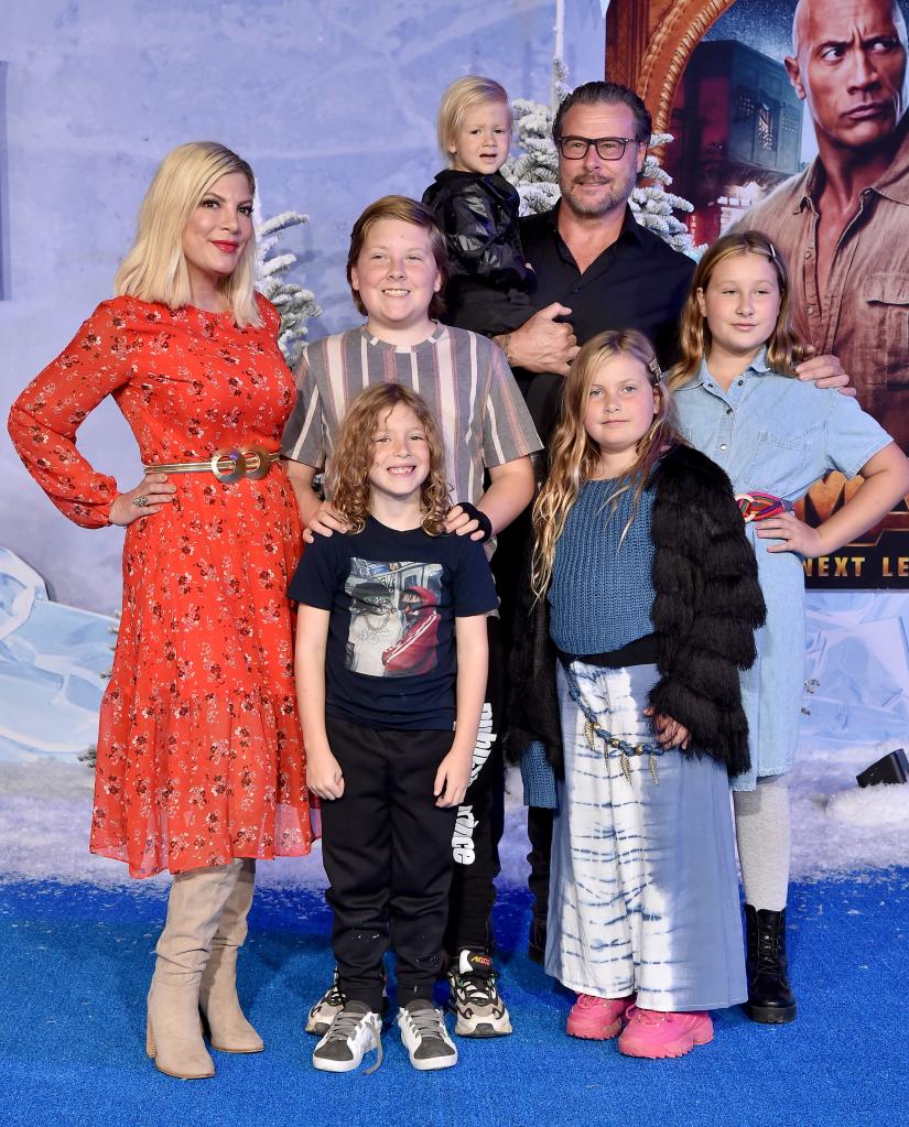 Tori Spelling and Dean McDermott posing with their kids on a red carpet.