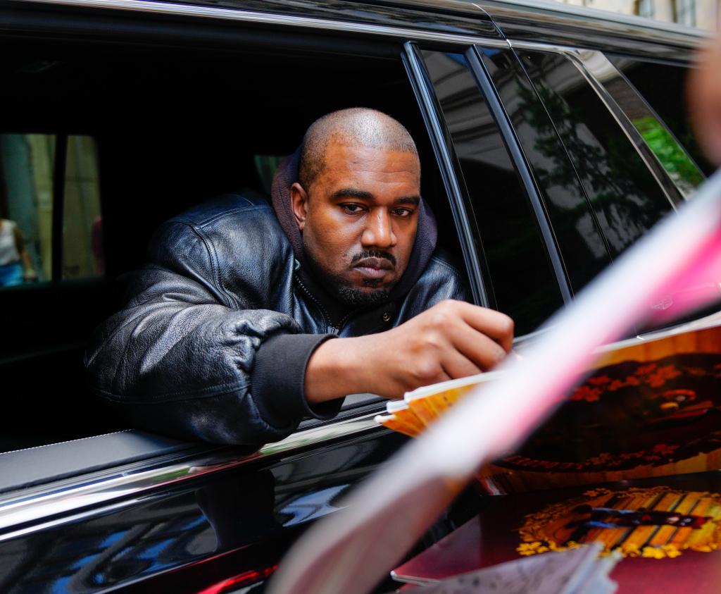 Kanye West signing an autograph.