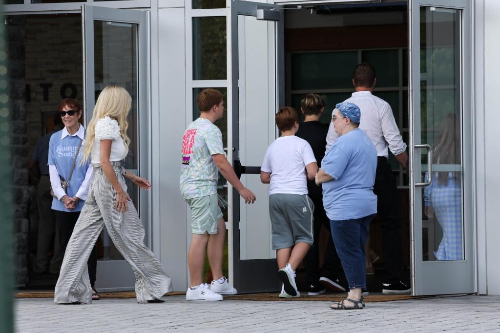 kim zolciak and kroy biermann walking with their kids into a building