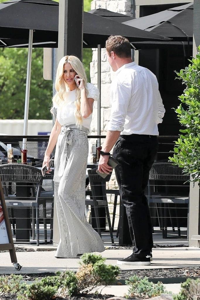 kim zolciak talking on her cell phone standing next to kroy biermann