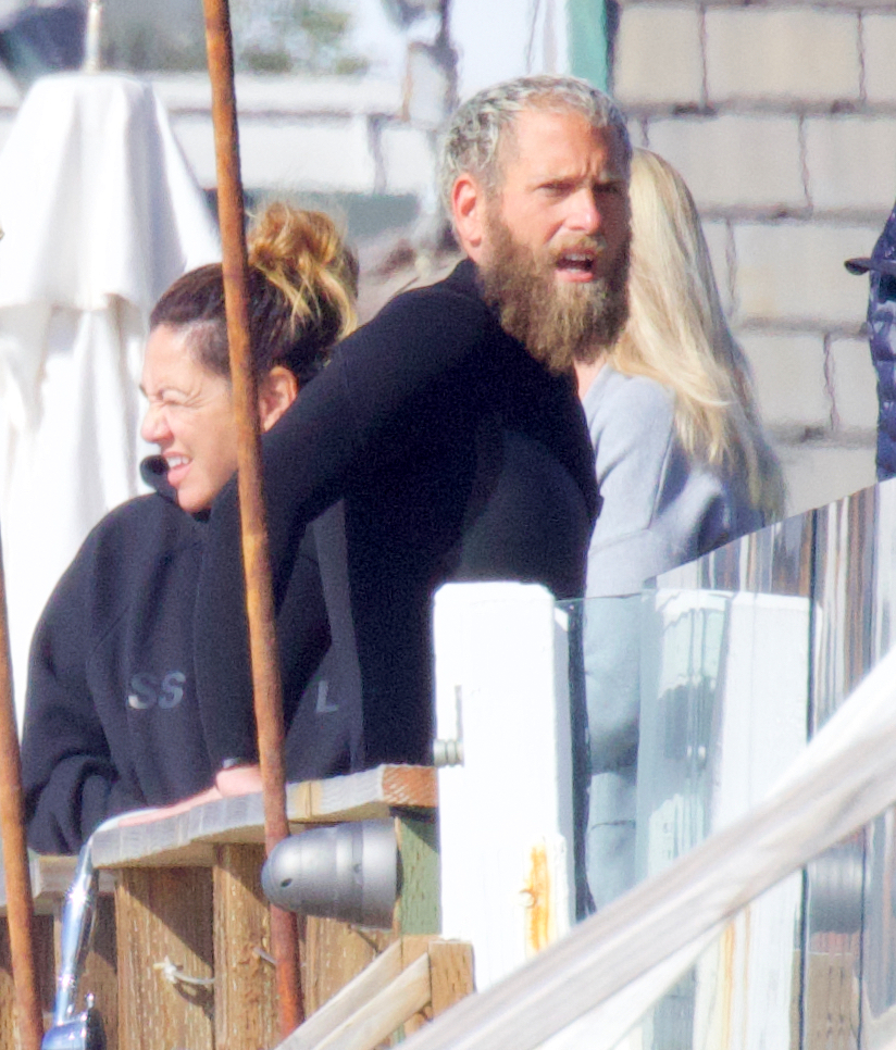 jonah hill in a wet suit leaning on a dock