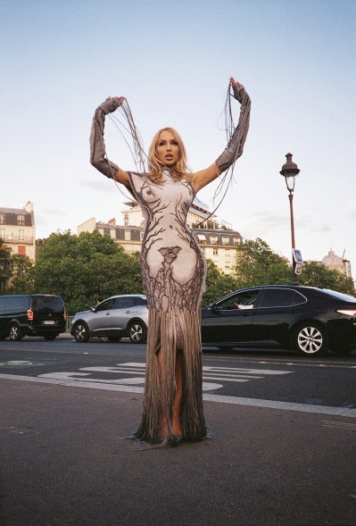 Christine Quinn posing in a "naked" dress on a sidewalk in paris