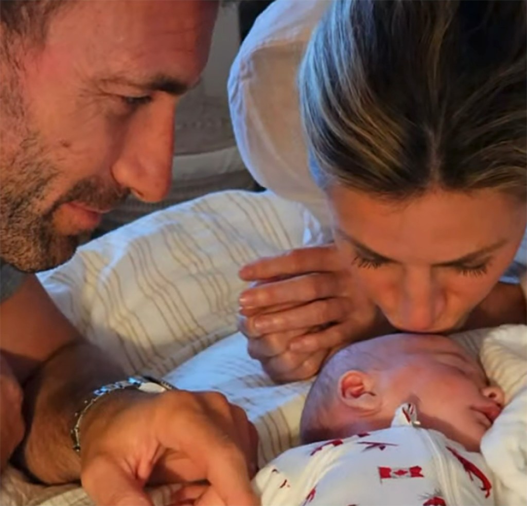 erin andrews kissing her baby's head while her husband, jarret stoll, looks on adoringly