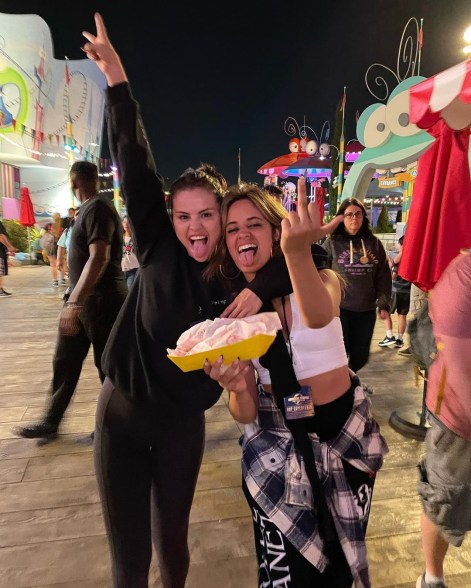 Selena Gomez and Camila Cabello sticking their tongues out at a carnival