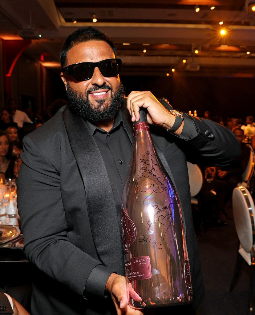 DJ Khaled posing with a big bottle of champagne.