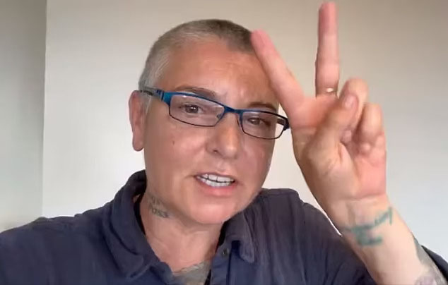 sinead o'connor giving a peace sign with her fingers