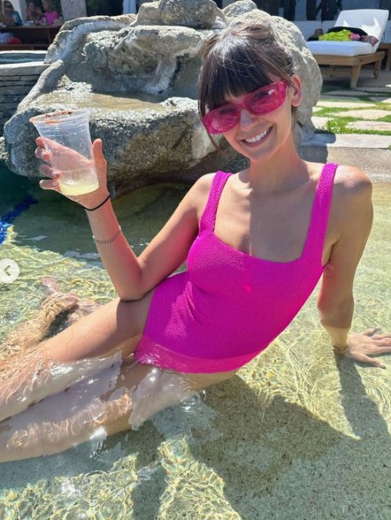 nina dobrev lounging in the ocean with a drink