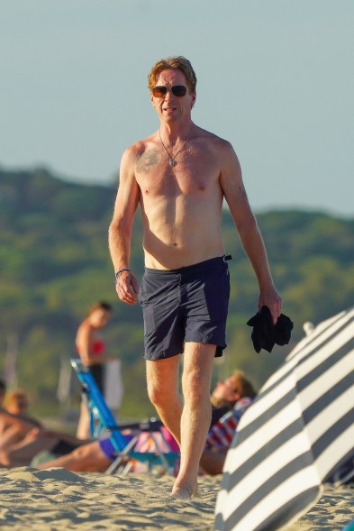 shirtless damien lewis going for a walk on the beach