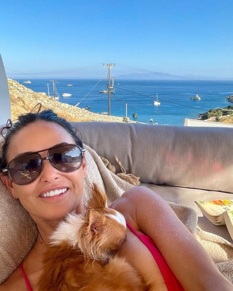demi moore lying on a couch with her dog with the ocean in the background