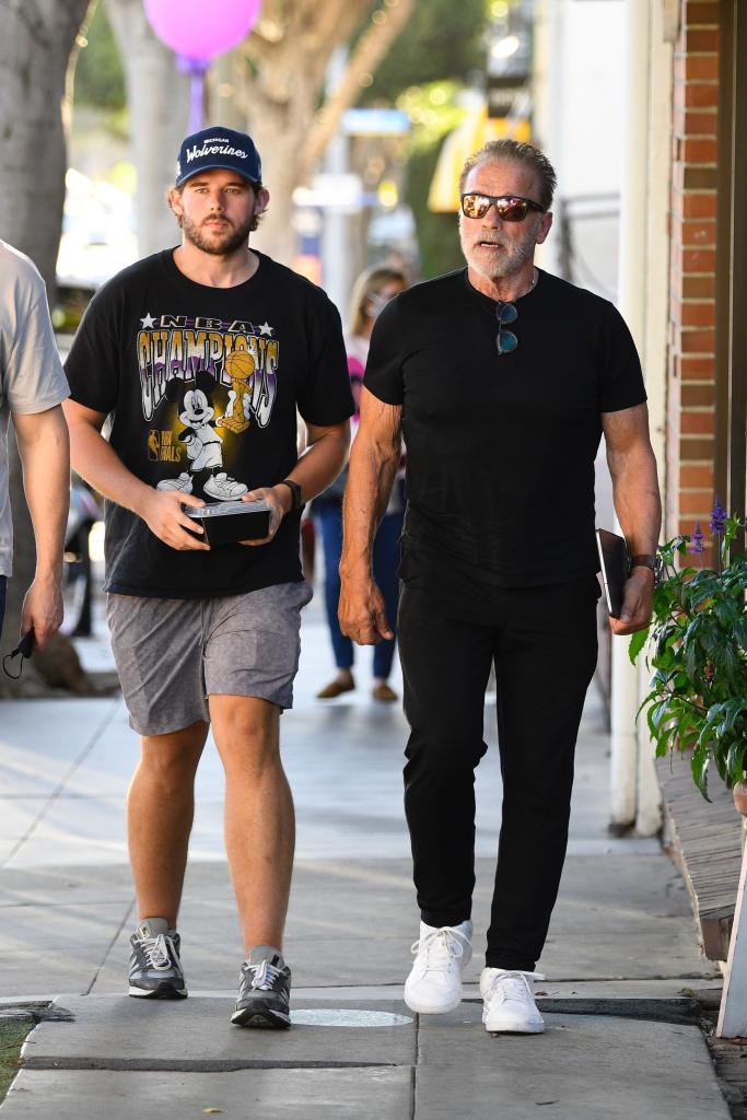 Christopher and Arnold Schwarzenegger walking together.