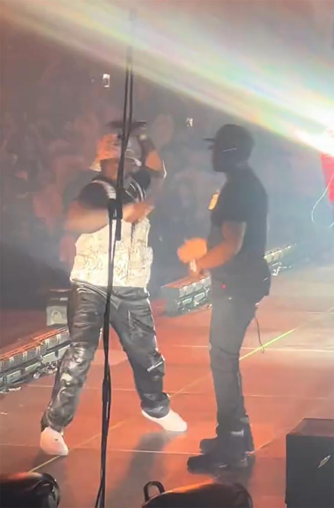 50 cent on stage throwing a microphone next to rapper YG
