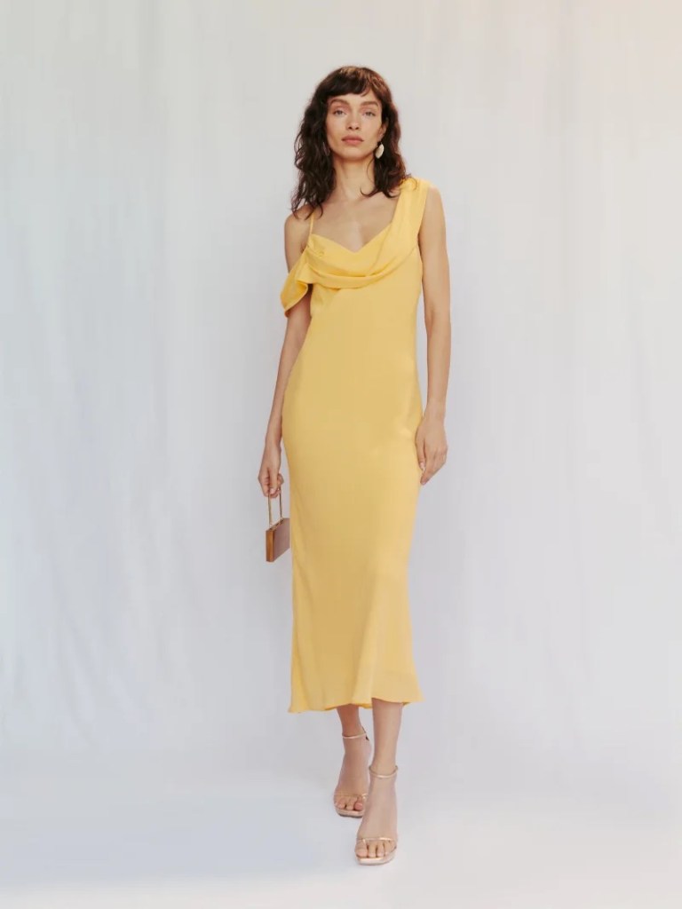 A model in a yellow draped dress