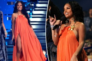 Halle Bailey in orange dress on stage at the MTV Awards.