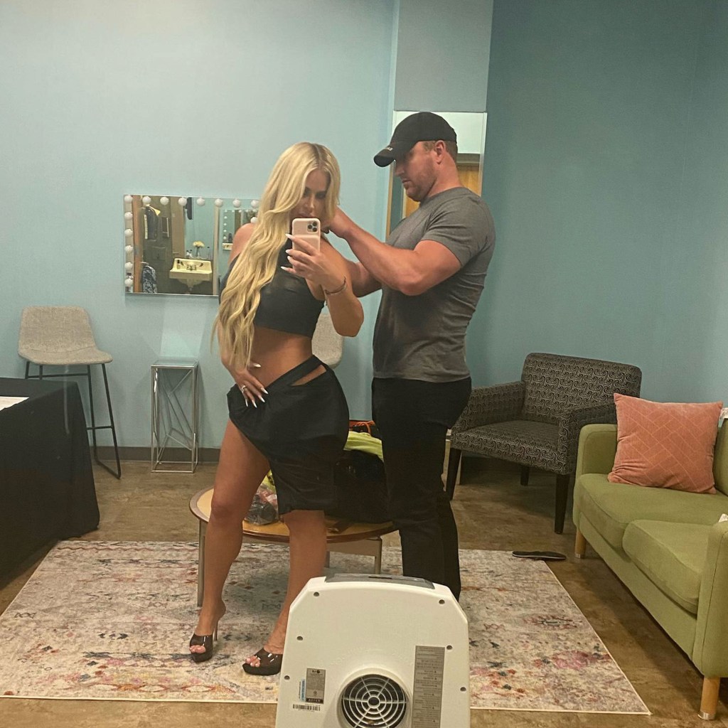 kim zolciak taking a mirror selfie while kroy biermann fixes her top