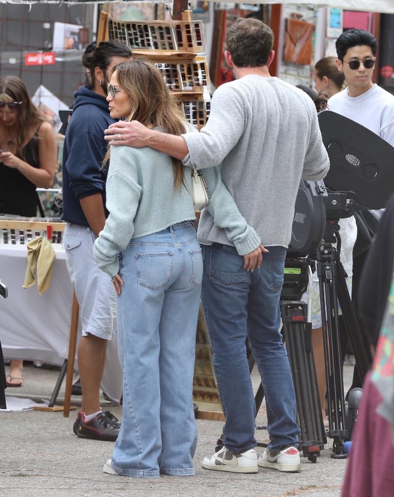 jennifer lopez and ben affleck with one arm holding the other 