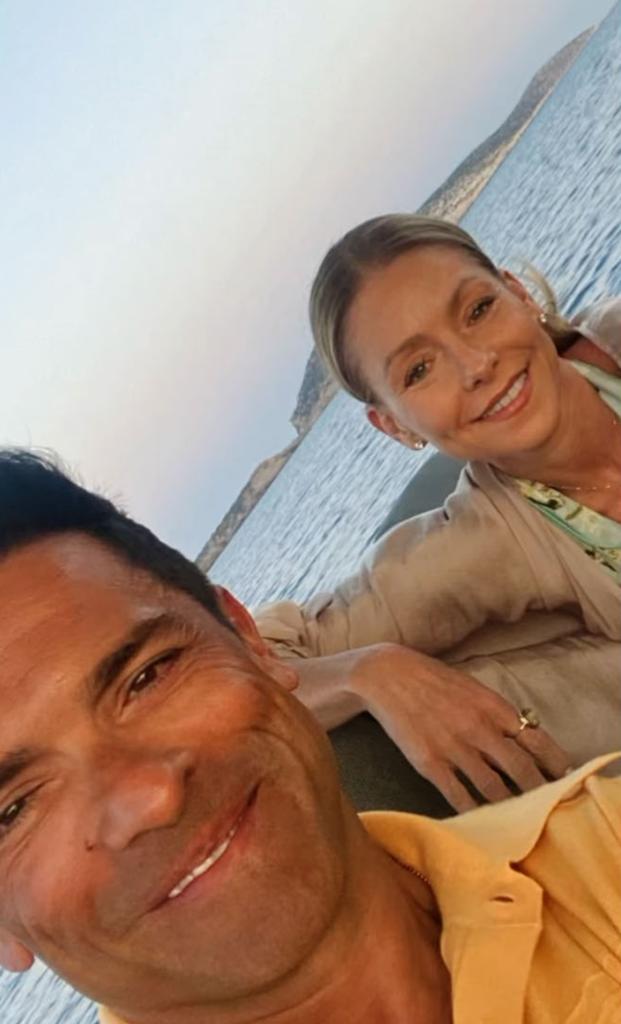 Kelly Ripa and Mark Consuelos smile for a selfie on a boat.