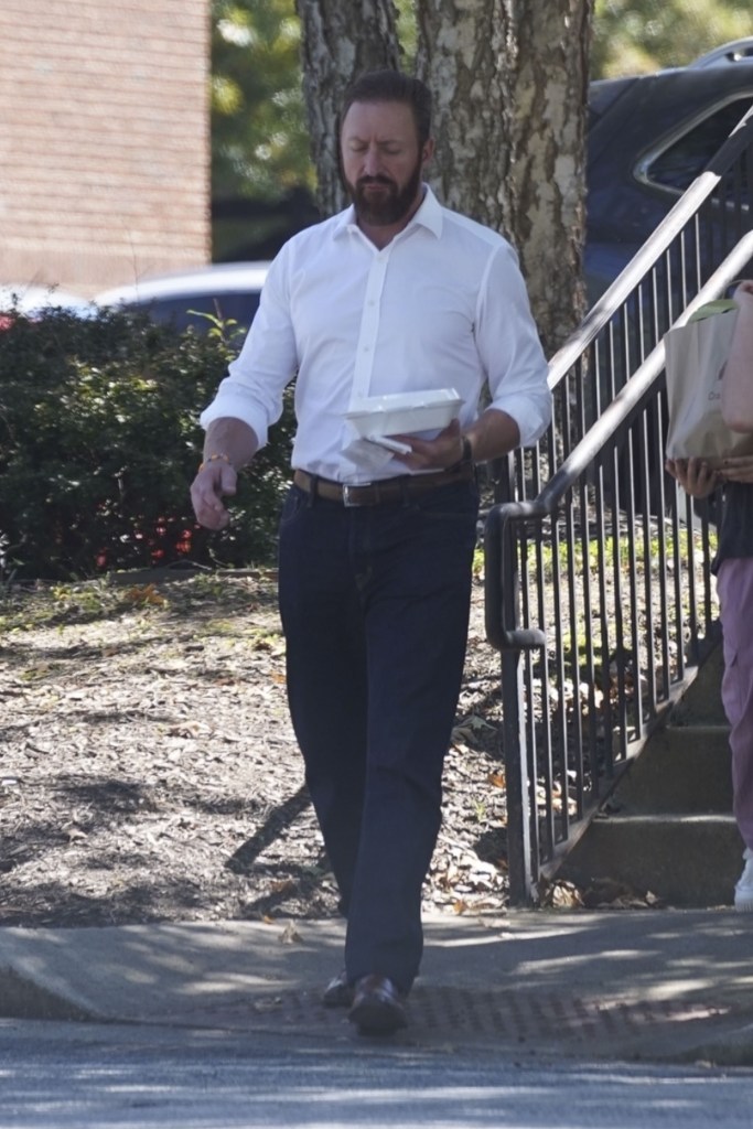 bearded kroy biermann walking with a carton of food in his hand