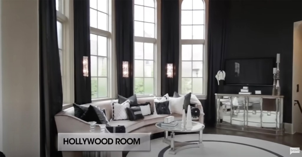 a black-and-white-themed living room with large bay windows