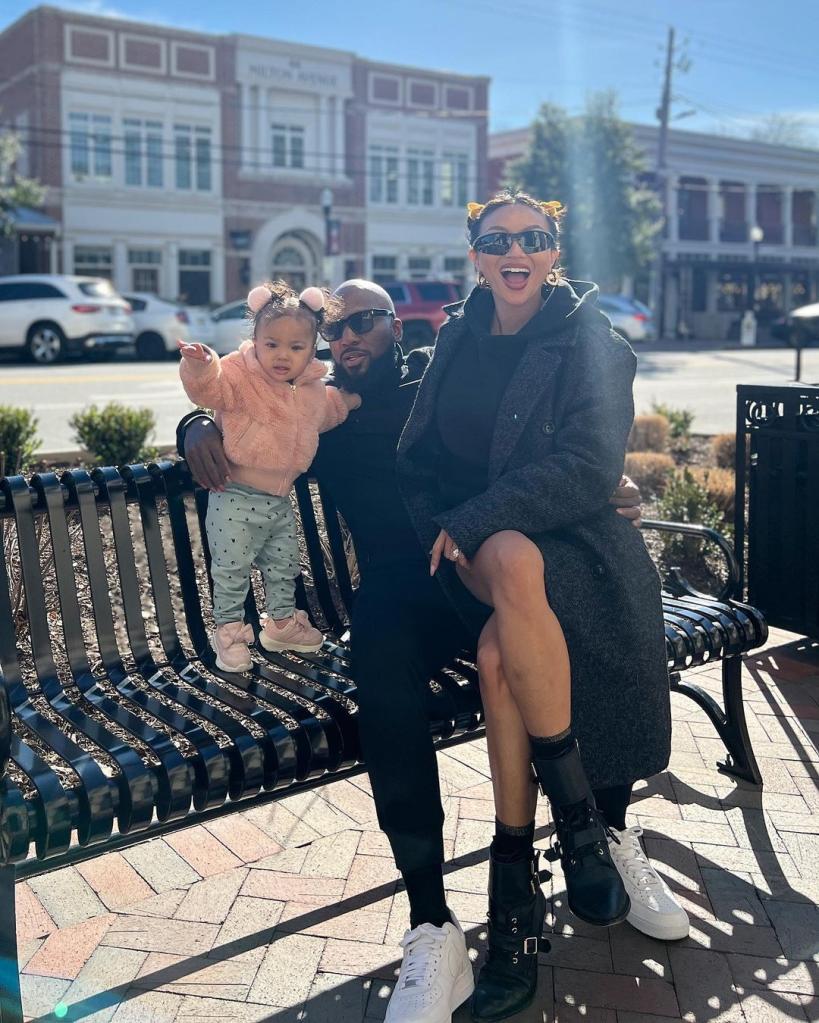 jeannie mai, jeezy and daughter monaco sitting on a bench