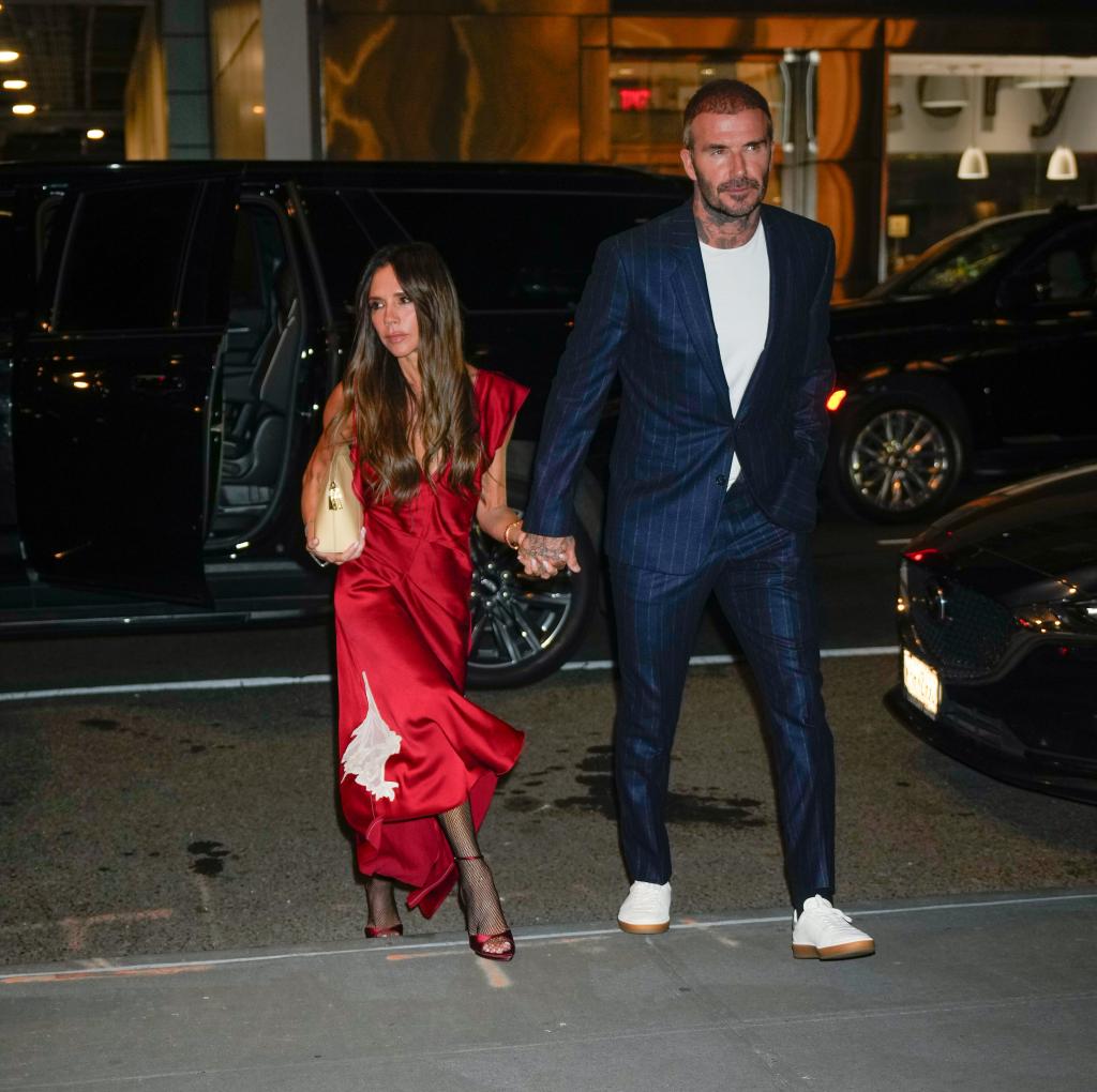 David and Victoria Beckham walking while on a date in New York City. Victoria had on a red silky dress, while David dressed in a blue pinstripe suite.